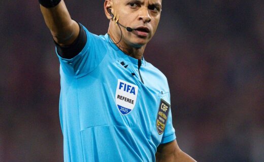 Árbitro de futebol com uniforme azul.