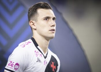 Jogador do Vasco em uniforme branco com detalhes pretos e rosa.