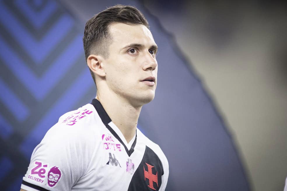 Jogador do Vasco em uniforme branco com detalhes pretos e rosa.