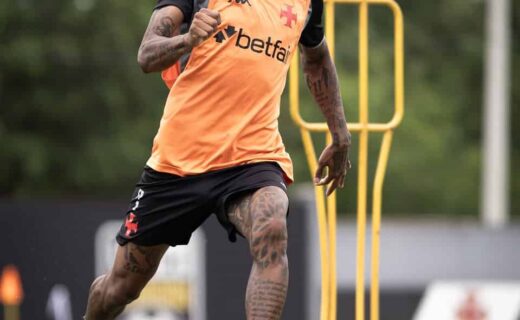 Goleiro treinando com bola durante treino no campo.