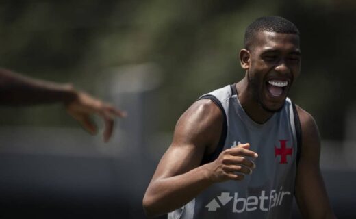 Jogador sorrindo, treino ao ar livre.