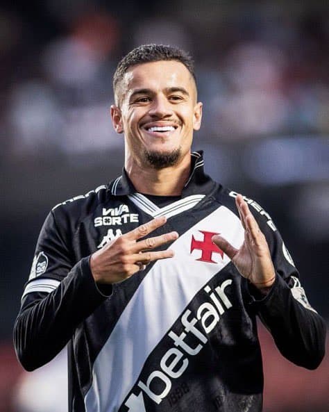 Jogador do Vasco sorrindo com uniforme preto e branco.