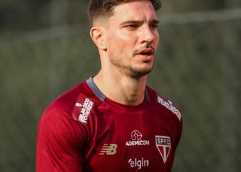 Vasco jogador de futebol em campo com uniforme vermelho.
