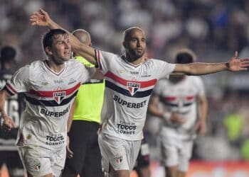 SPFC jogando em campo de futebol durante partida noturna.