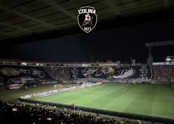 Estádio de futebol lotado à noite.