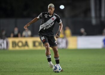 Jogador do Vasco em campo durante jogo noturno.