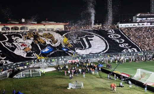 Vasco da Gama torcedor com bandeira gigante no estádio.