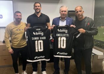 Jogadores e dirigentes do Vasco segurando camisas de jogo.