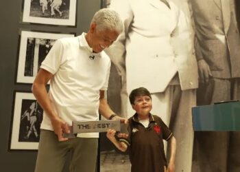 Vidro de homenagem do Vasco com jovem e idoso sorridentes.