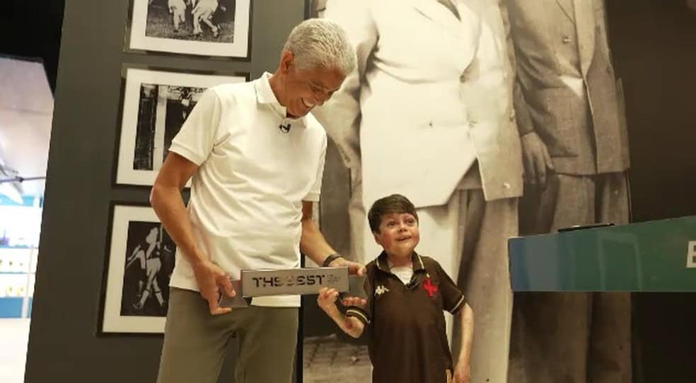 Vidro de homenagem do Vasco com jovem e idoso sorridentes.