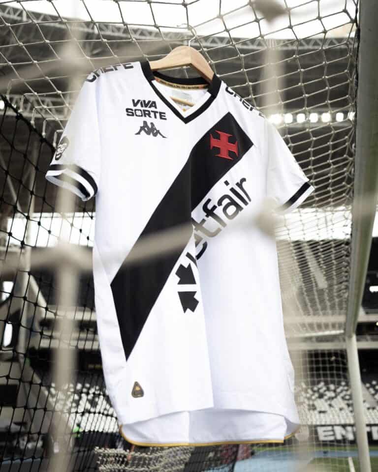 Camiseta do Vasco pendurada na grade do estádio, destaque para detalhes do uniforme com logos e cores.