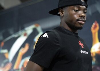 Jogador do Vasco com boné preto e camiseta preta.