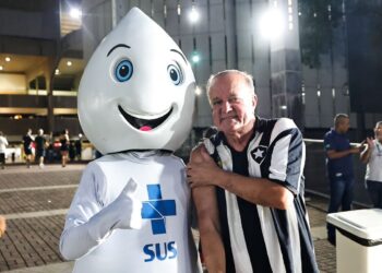 Mascote do Vasco com torcedor em evento noturno no estádio.