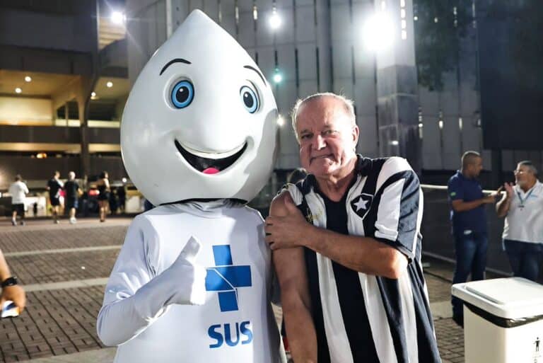 Mascote do Vasco com torcedor em evento noturno no estádio.