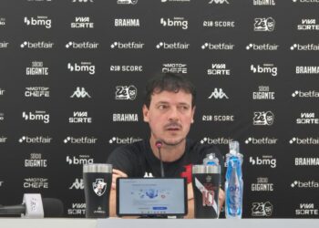 Goleiro durante entrevista coletiva com banners do Vasco ao fundo.