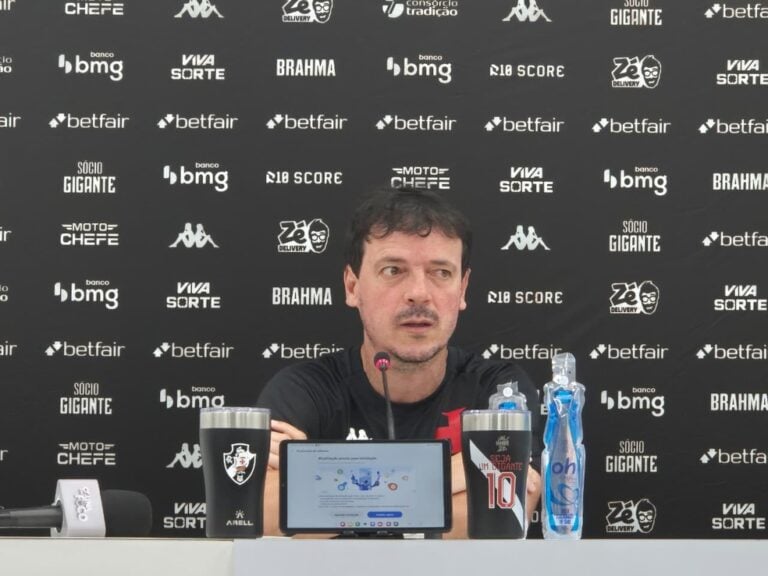 Goleiro durante entrevista coletiva com banners do Vasco ao fundo.