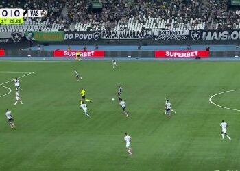 Jogadores em campo durante partida de futebol.