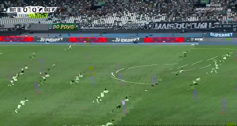 Jogadores em campo durante partida de futebol.