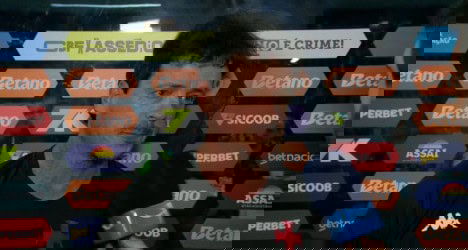 Homem em entrevista com microfone azul.