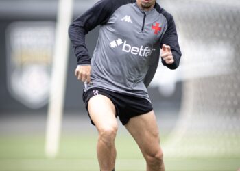 Jogador treinando com bola no campo.