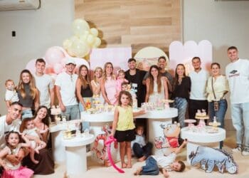 Festa infantil com crianças e adultos sorrindo juntas.