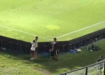 Estádio de futebol com técnicos e equipe de suporte.