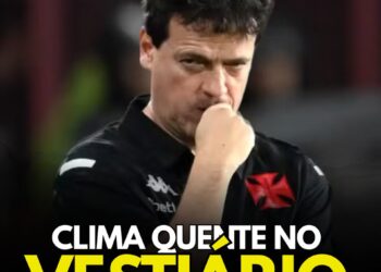 Vasco coach pensativo com uniforme preto, fundo escuro.