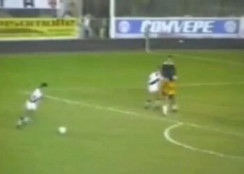 Jogador do Vasco em ação no campo de futebol.