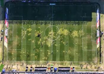 Futebol em campo com manchas de tinta amarela.