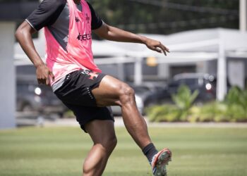 - Jogador de futebol treinando com chuteira no campo outdoor.