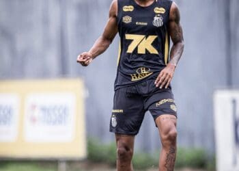 Jogador do Santos com bola nos pés em treino ao ar livre.