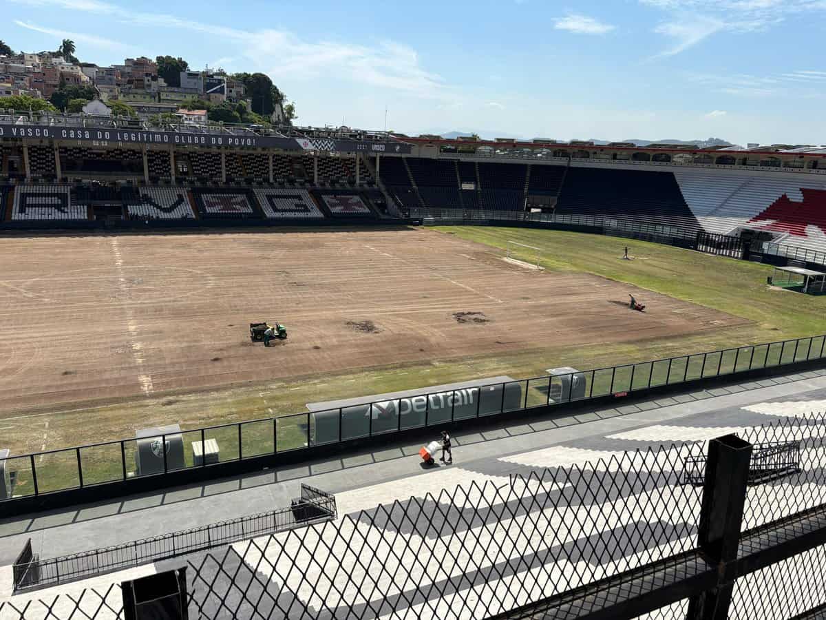Linha de fundo: Estádio do Vasco com gramado em reforma e arquibancadas vazias.