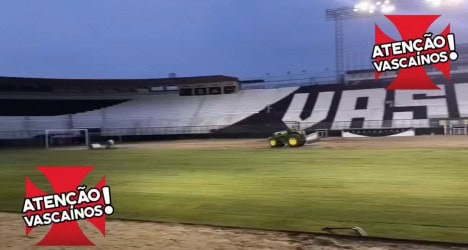 Estádio do Vasco iluminado à noite com publicidade.