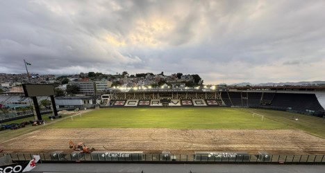 Estádio de futebol vazio ao entardecer.