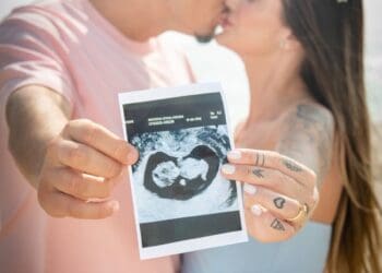 1. Gestante segurando ultrassom na praia.