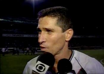 Jogador de futebol com cabelo curto e camisa branca.