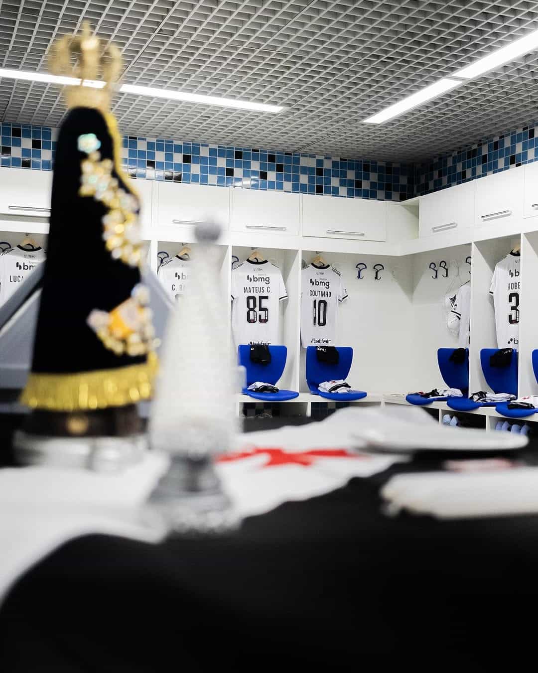 Bancada de vestiário do Vasco com camisas e cadeiras.