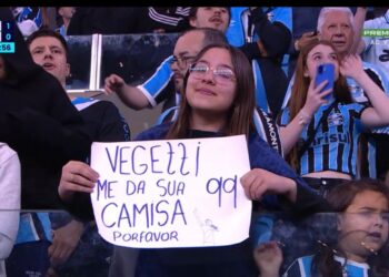 Vasca torcedor segurando cartaz no estádio.