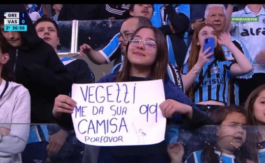 Vasca torcedor segurando cartaz no estádio.