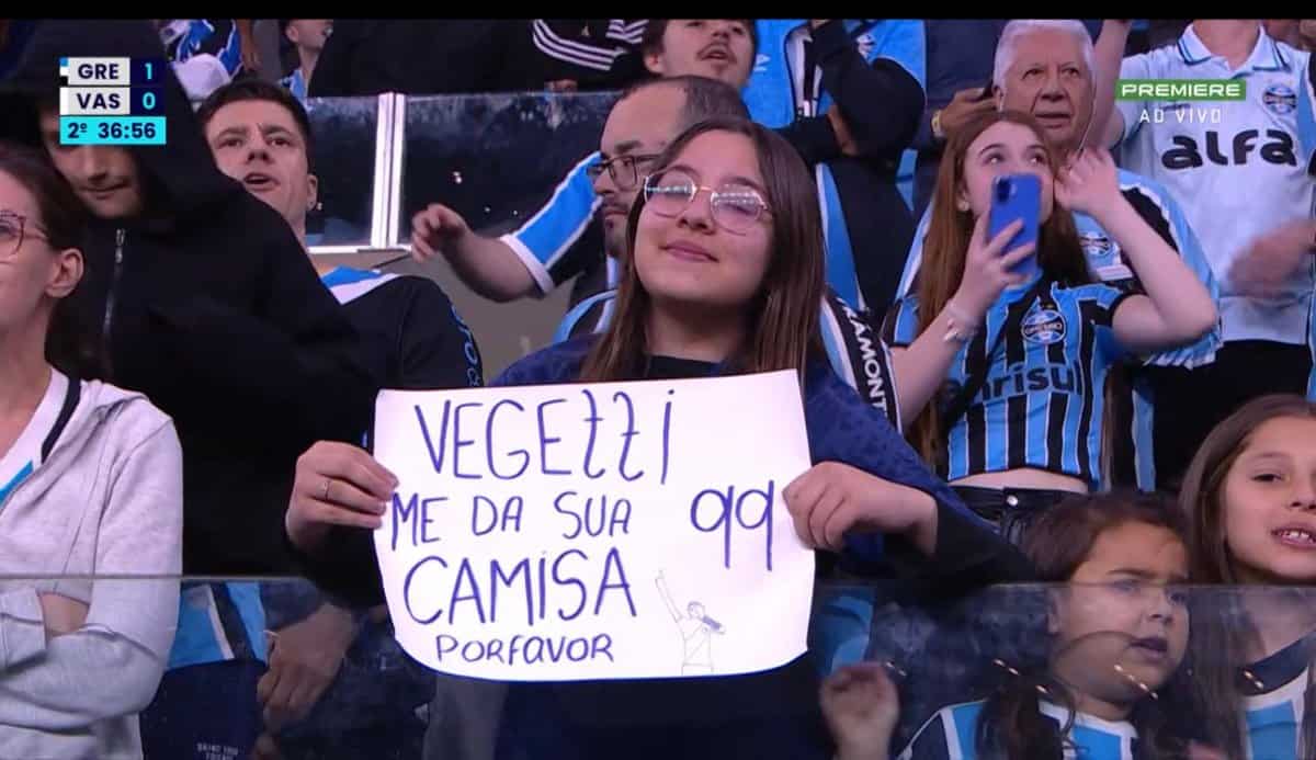 Vasca torcedor segurando cartaz no estádio.