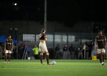 Jogadores do Vasco treinando no campo à noite.
