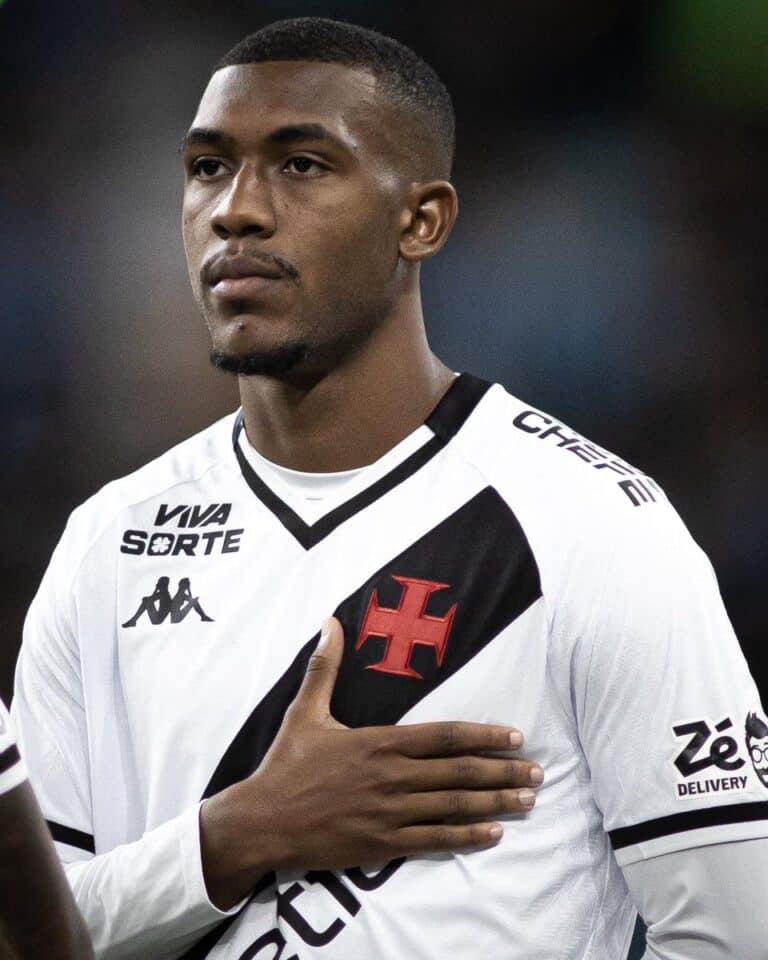 Jogador do Vasco com uniforme branco e preto em destaque.
