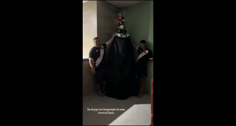 Um grupo de pessoas ao lado de uma árvore de Natal decorada.