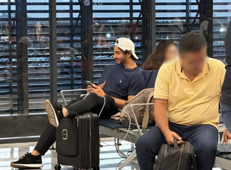 1. Jovem usando camiseta azul e boné branco.