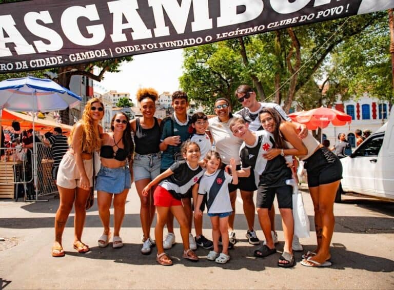 Fans do Vasco comemorando na rua com bandeira gigante.