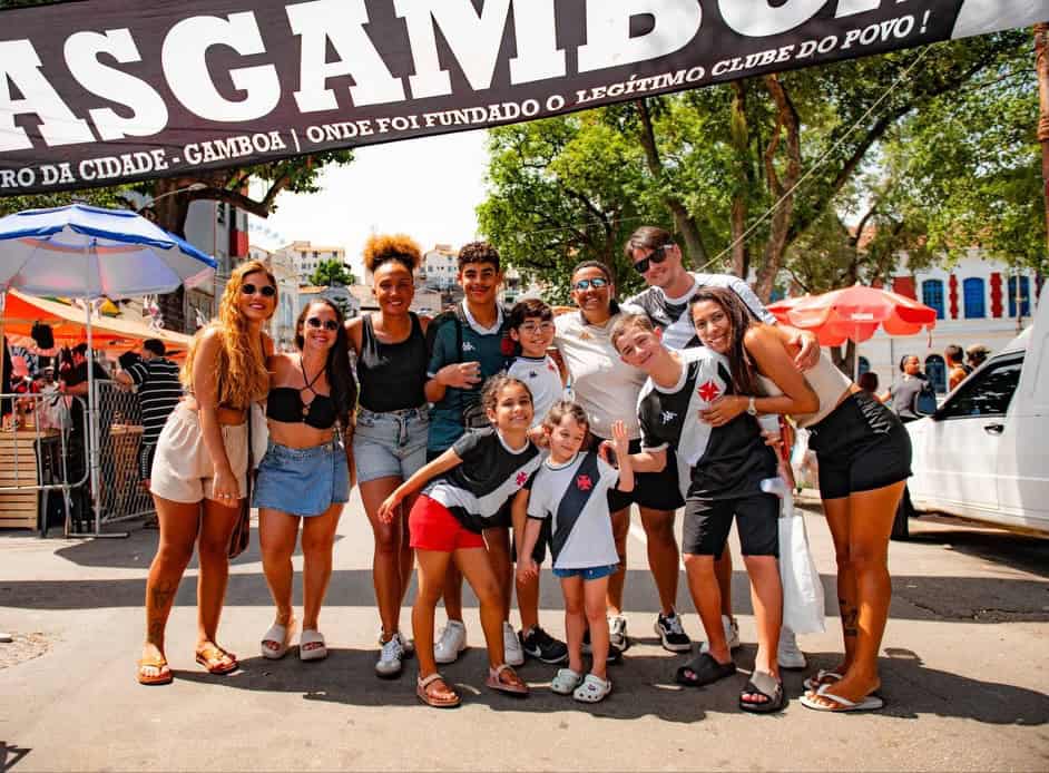 Fans do Vasco comemorando na rua com bandeira gigante.