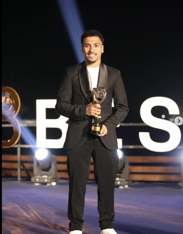 Campeão segurando troféu em cerimônia de premiação.