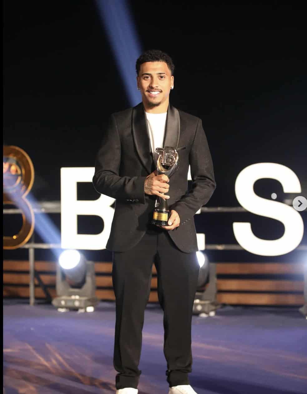 Campeão segurando troféu em cerimônia de premiação.