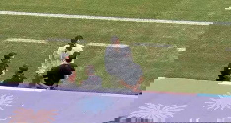 Homens conversando no campo de futebol.