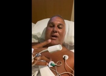 Homem deitado em hospital, com equipamento médico.